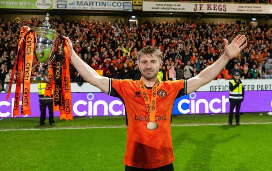 Ross Docherty holds aloft Dundee United's Championship trophy last season