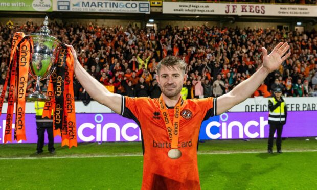 Ross Docherty holds aloft Dundee United's Championship trophy last season