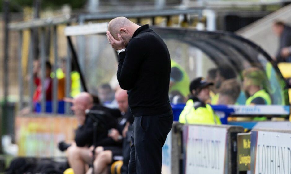 Pars manager James McPake holds his head in his hands during the defeat to Livingston.