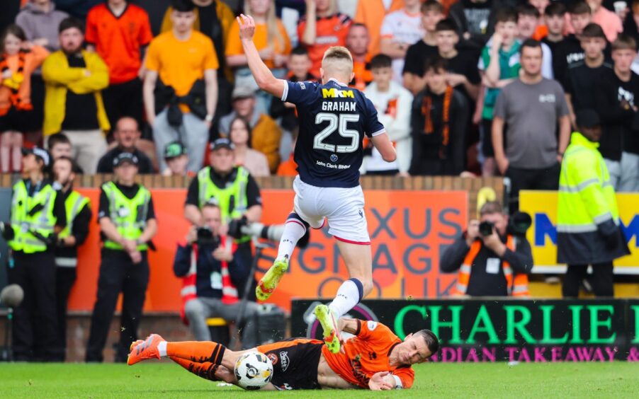 Dundee United's David Babunski, sporting the armband, gets stuck in on derby day