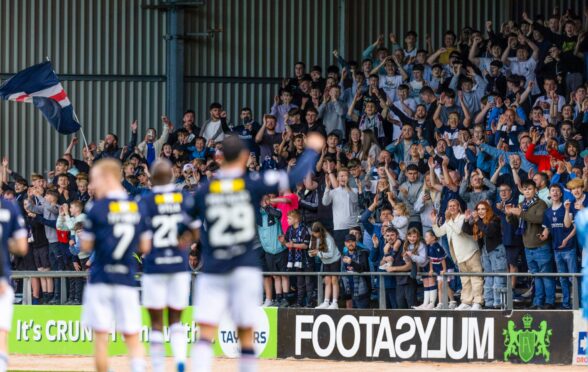 Dundee fans and players celebrate at full-time after seeing off Hearts. Image: SNS