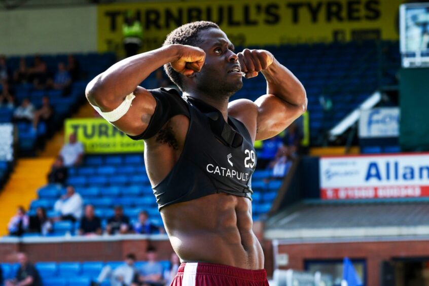 Benji Kimpioka flexes his muscles in the direction of the Saints fans after a game