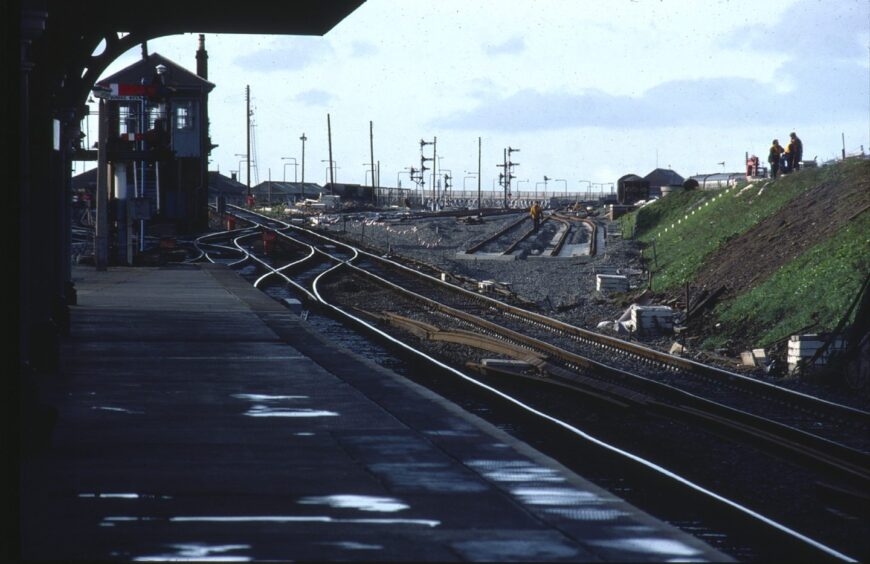 Workers on an embankment and the tracks amid changes in the 80s