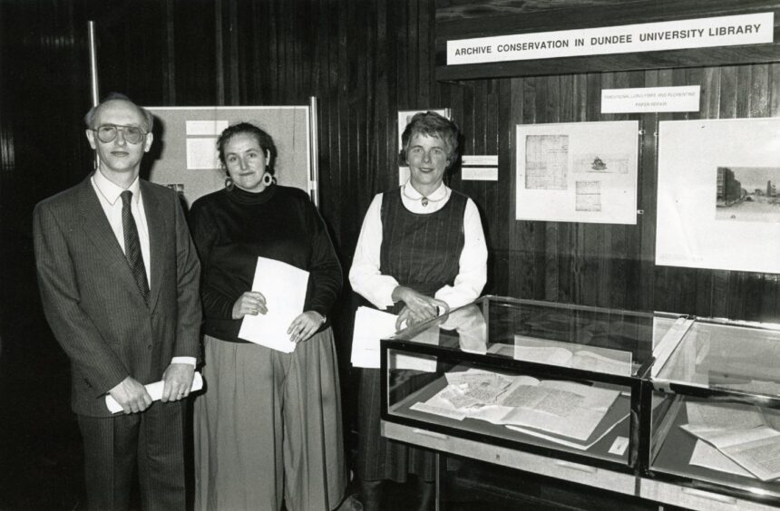 Officials stand beside a display of the work of Linda Ramsay, pictured in the middle of the three