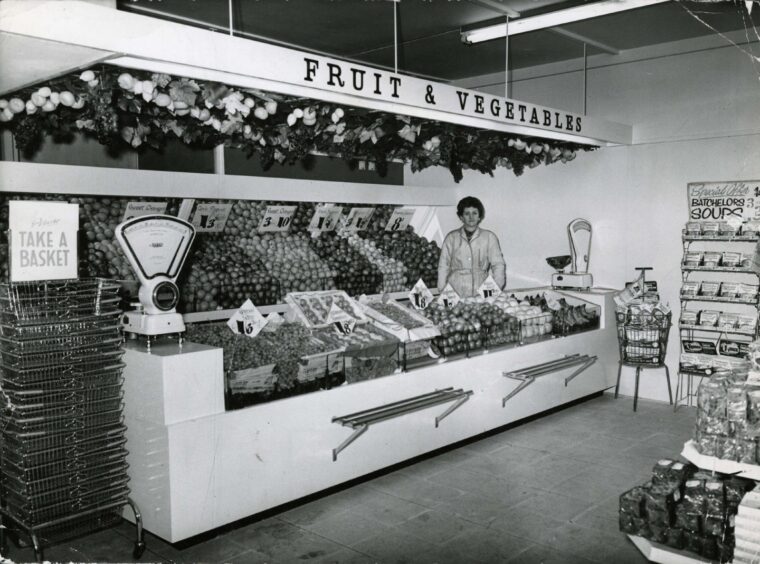 A woman behind the fruit and vegetable counter at the old William Low shop in Perth Road in 1963. 