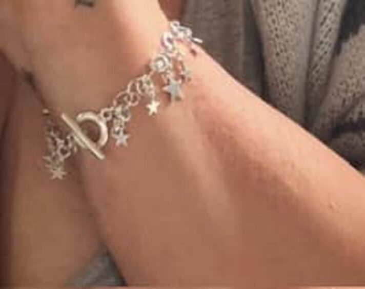 Close-up of silver bracelet with silver star shaped charms