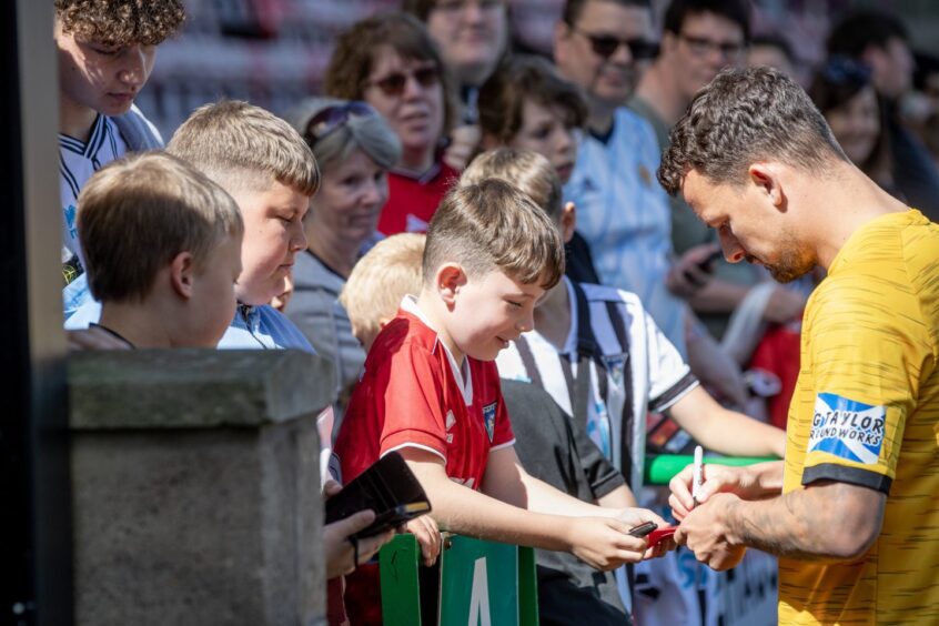 Kyle Benedictus signs autographs at Dunfermline's open training session.