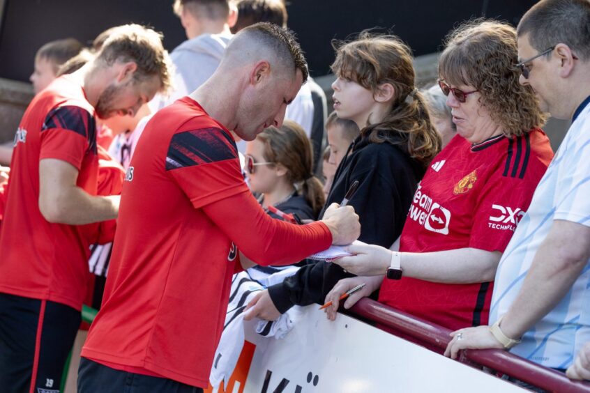 Michael O'Halloran works his way along the supporters after training. 