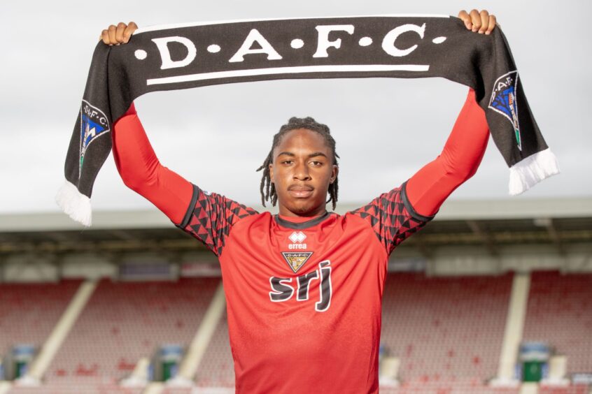 Celtic goalkeeper Tobi Oluwayemi holds up a Dunfermline Athletic scarf.