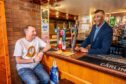 Raj Joshi behind bar with Andy Strike seated enjoying pint