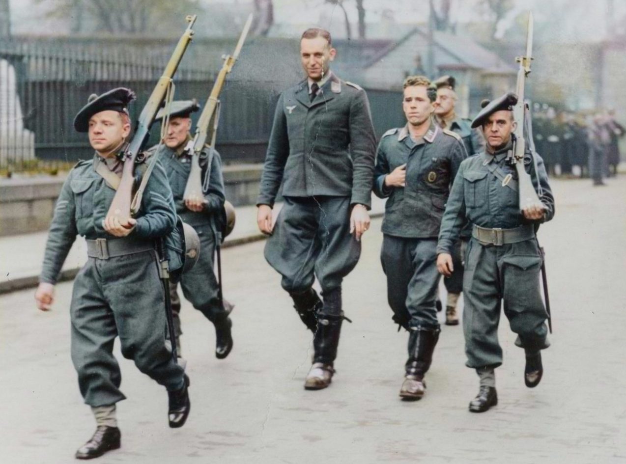 Four armed British soldiers march two German aircrew down Bell Street in Dundee during the Second World War