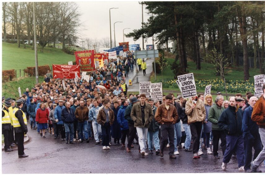 People take part in the Timex demonstration march and rally in 1993, as police look on.