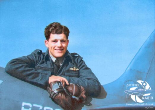 Sandy Gunn leaning over Spitfire aircraft