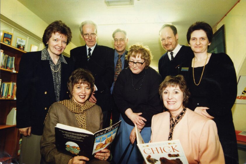 Education director Anne Wilson and officials check out some books as the library is opened in March 1997.