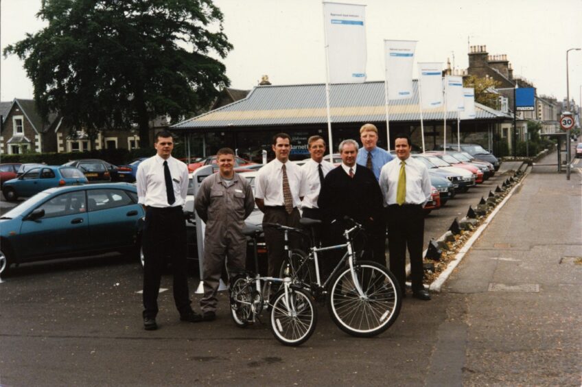 Staff members outside the Broughty Ferry car showroom in 1997, with the building and vehicles in the background