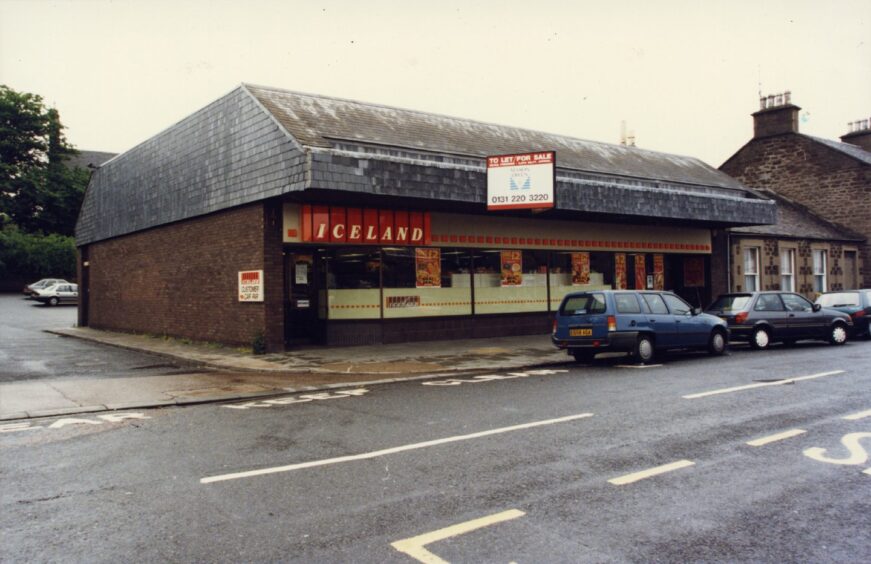 The outside of the Iceland store in Broughty Ferry, with some cars parked at the kerb