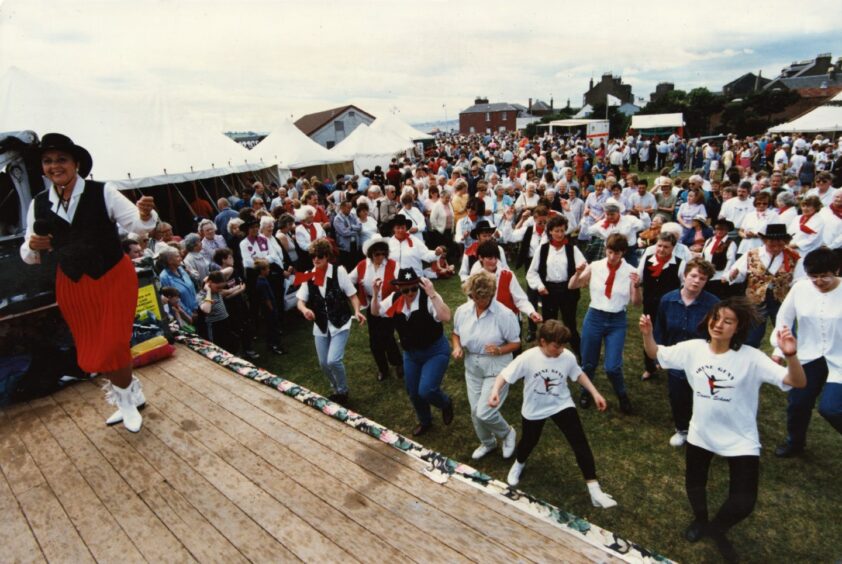 Irene Gunn, on a stage, leads the line dancers at Castle Green in July 1997. 