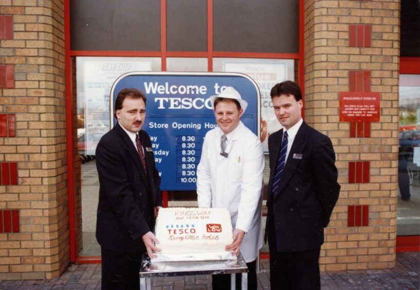 Three employees outside a new Tesco store with a birthday cake that marked the bittersweet occasion in 1994. 