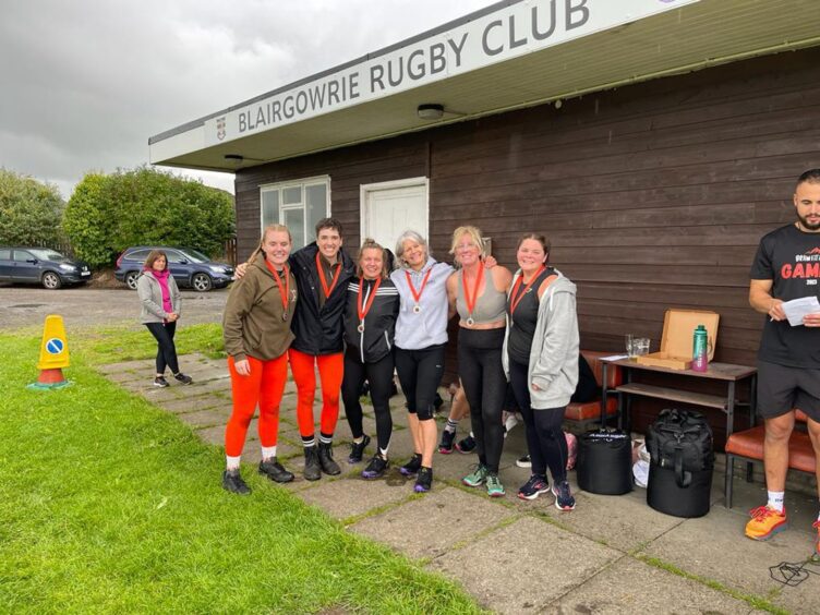 Group of women in fitness gear standing in front of Blairgowrie Rugby Club clubhouse