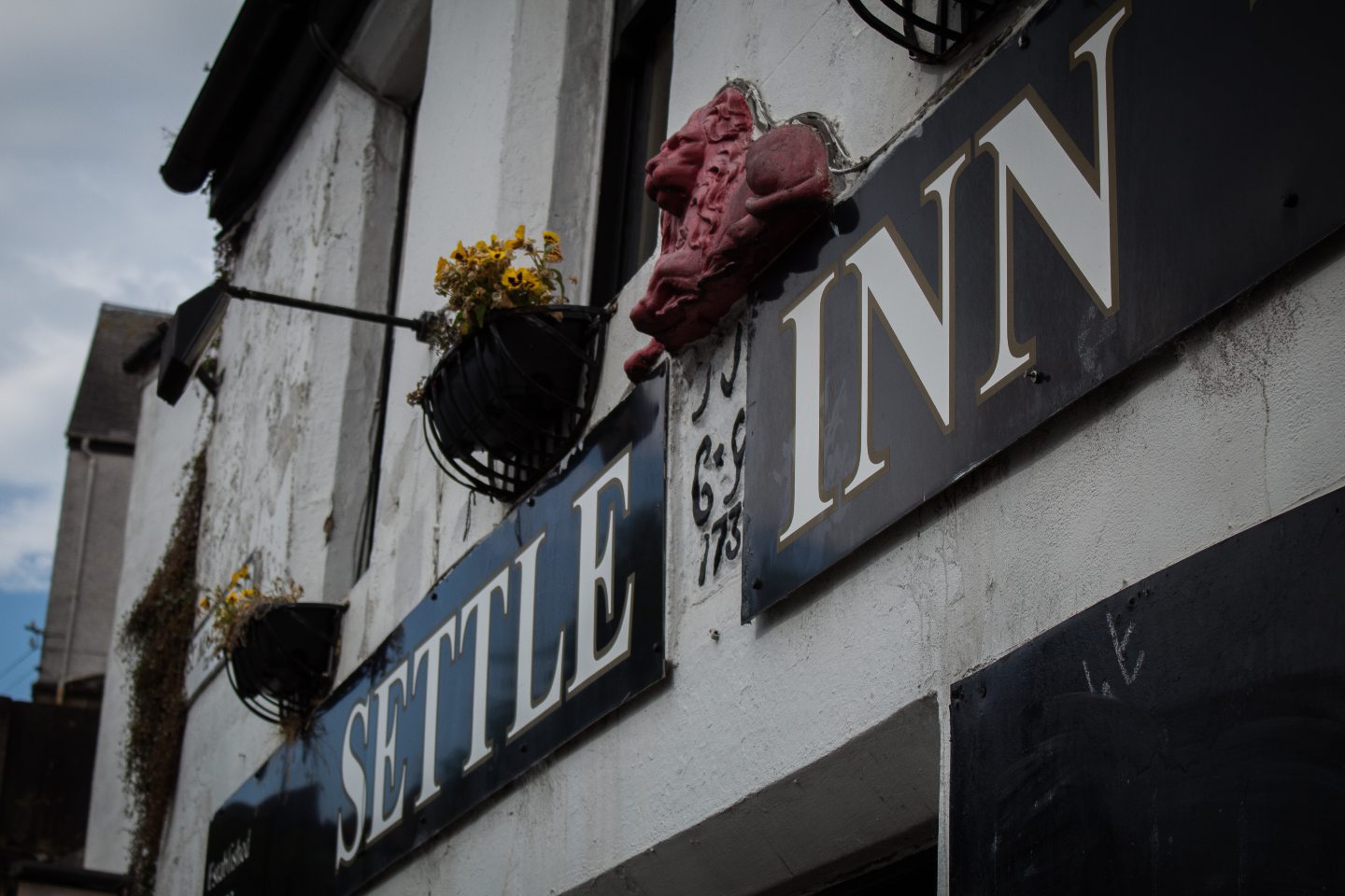 Sign reading 'Settle Inn' with a lion and flowers. 