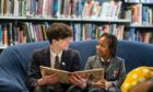 Two students from the Highschool of Dundee reading a book.