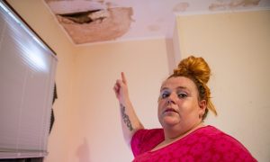 Sarah Bentham in her children's bedroom with an unrepaired hole in the background in Linlathen, Dundee.