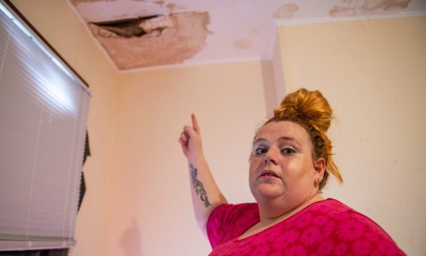 Sarah Jane Bentham has a huge hole in the ceiling of her bedroom in her council house. Been growing worse since last April and DCC done nothing about it - they have fixed the leaking roof but done nothing about the internal hyole. Picture Shows; Sarah Bentham (correct) in her childrens bedroom with the unrepaired hole in the background, Blacklock Crescent, Linlathen, Dundee, 01st August 2024. Image: Kim Cessford / DC Thomson