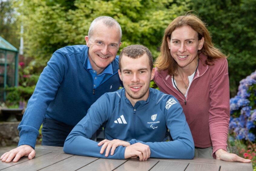 Ben Sandilands at garden table with his parents