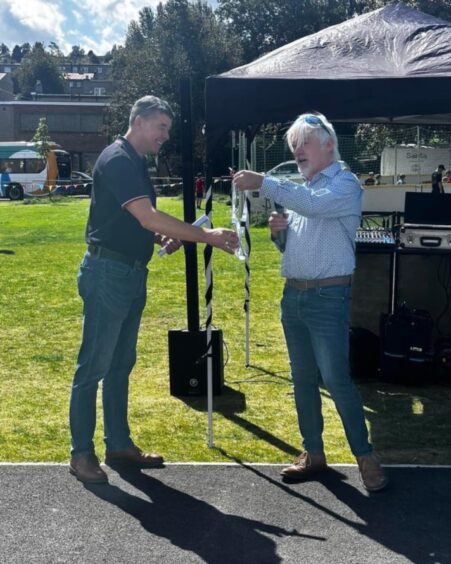 Gran Laing presenting keys to Alan Murray at Letham community barbecue