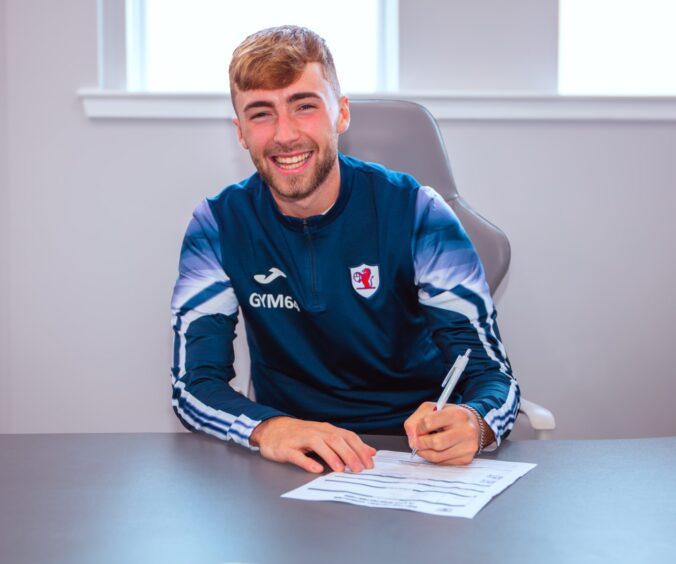 Lewis Jamieson signs his loan contract at Raith Rovers.