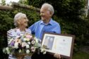 Mabel and Eddie Hartley smiling at one another in garden