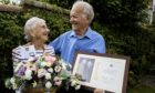 Mabel and Eddie Hartley smiling at one another in garden