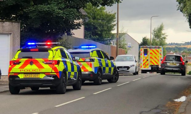 Police and an ambulance parked near the scene of the Strathmartine Road crash. Image: James Simpson/DC Thomson