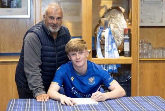 St Johnstone academy boss Alistair Stevenson watches as teen prospect Callan Hamill signs his new contract. Image: Graeme Hart/PPA