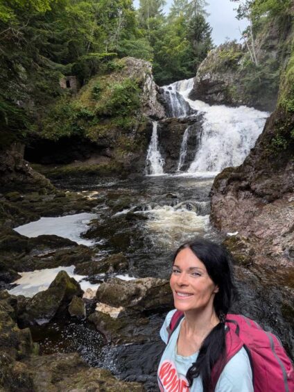 Reekie Linn: Gayle checks out the base of the falls, and the cave where the devil was said to have appeared in the form of a huge black dog. 