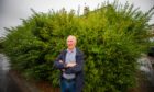 Peter Stewart with the overgrown hedge on Stirling Avenue in Dundee.