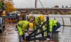 Council workers closing floodgates beside River Tay in perth