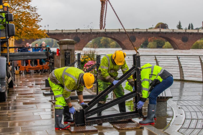 Council workers closing floodgates beside River Tay in perth