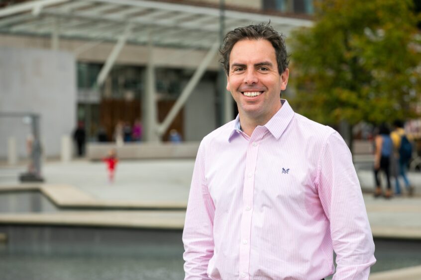 A picture of Maurice Golden. A man smiling in a pink shirt. 