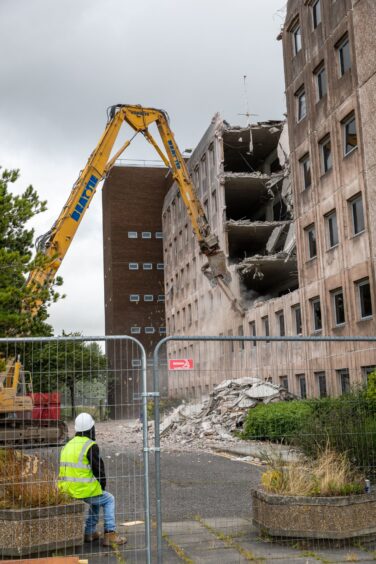 A mechanical digger is being used in the demolition process. 