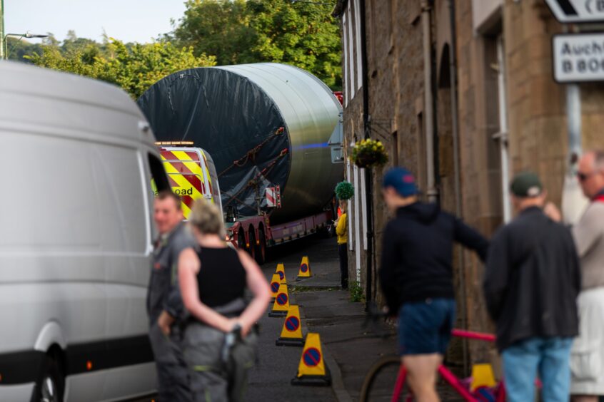 Locals watching lorry pass through narrow Dunning streets