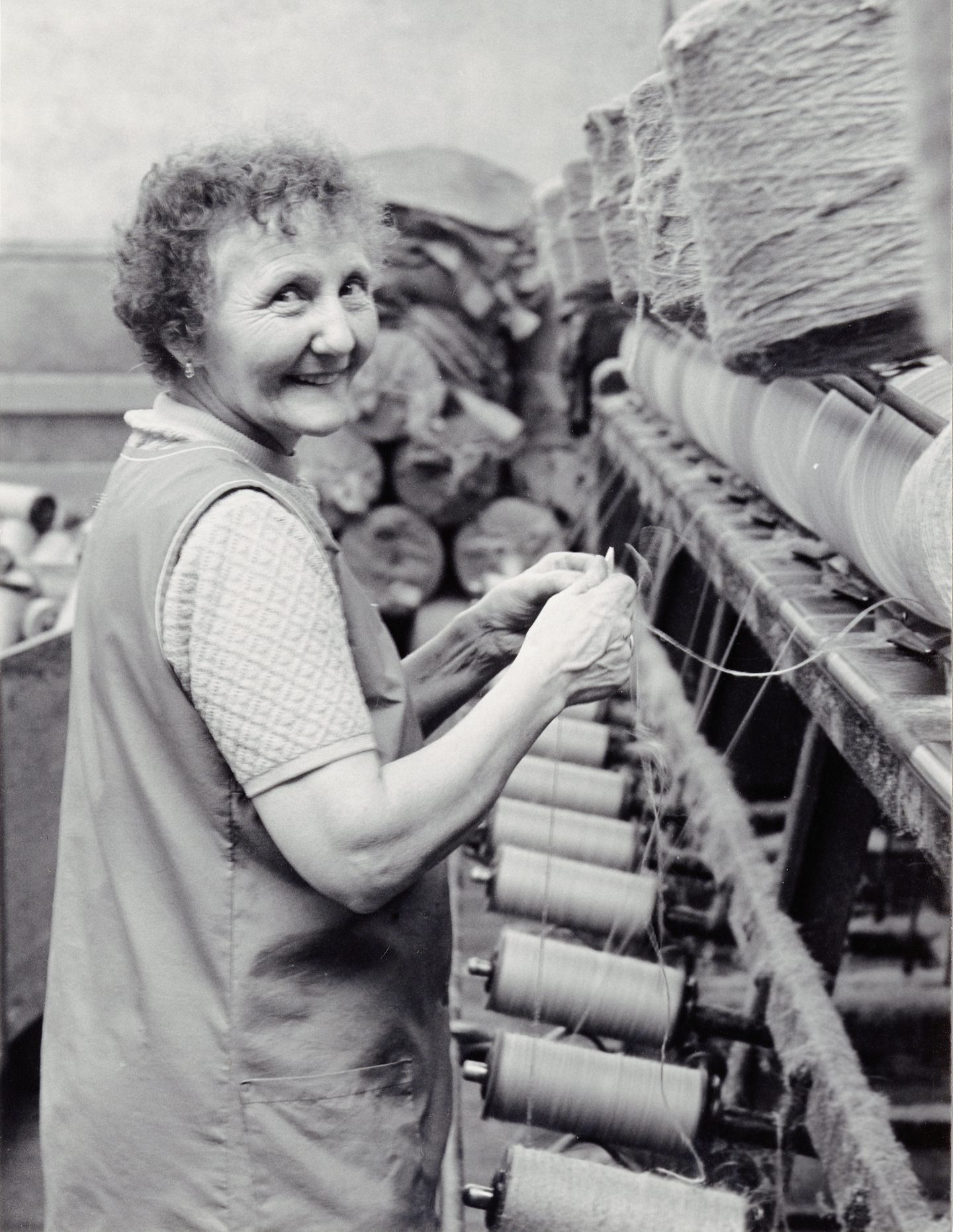 A smiling female spinner is busy at Constable Works in 1972.