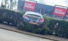 A dark grey Vauxhall ended up in a hedge at St Catherine's Retail Park, Perth