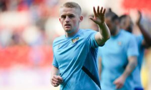 Cammy MacPherson waves to someone in the stand.