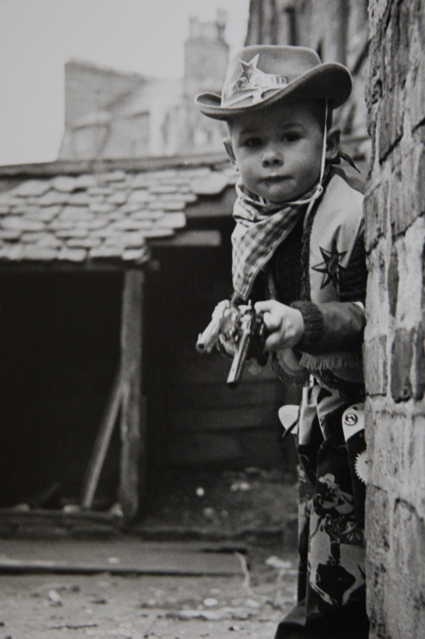 A young boy in a cowboy costume with two guns 