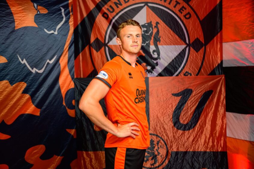 Sam Dalby, pictured in a Dundee United kit and in front of a club banner, cuts a physical presence at 6ft3ins