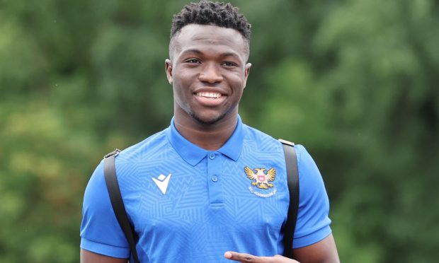 A smiling Adama Sidibeh in a St Johnstone t-shirt and wearing a backpack