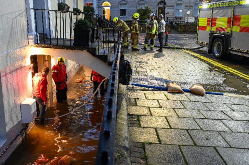 Fire crew on street and people up to their knees in basement properties in Perth