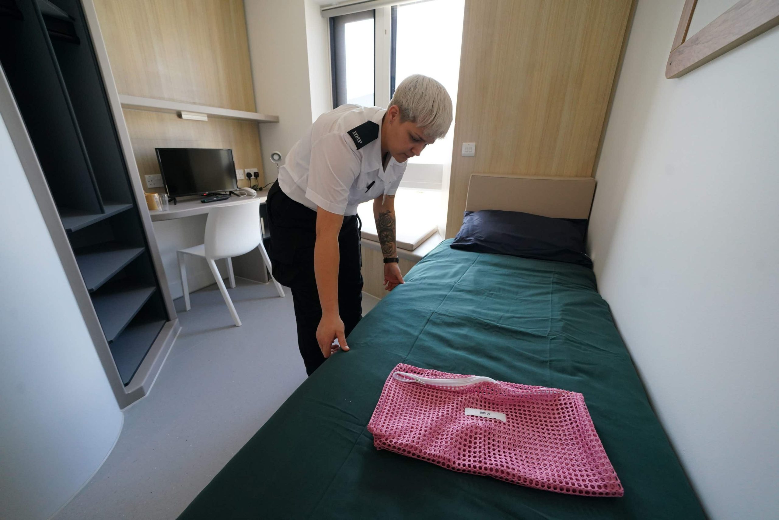 A prison officer makes a bed inside the custody units at HMP Stirling