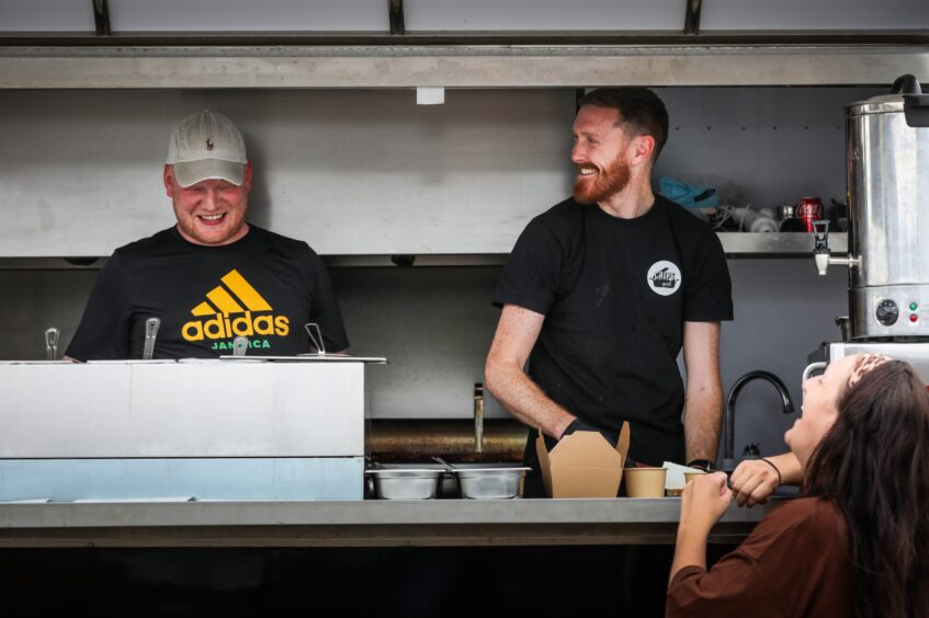 Charlie Carrie and Mark McDonald at the food truck serving customers.